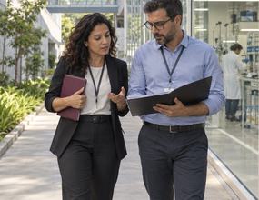 Executivos analisam iniciativas de pesquisa e desenvolvimento em um ambiente tecnológico, representando estratégia e gestão da inovação.